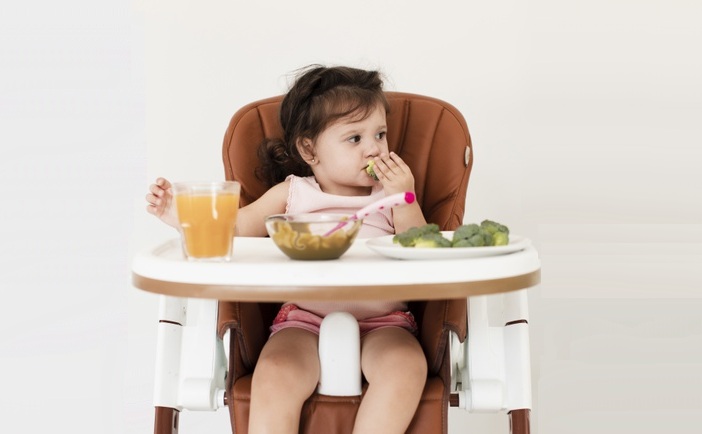 baby-girl-eating-child-chair_23-2148305213.jpg